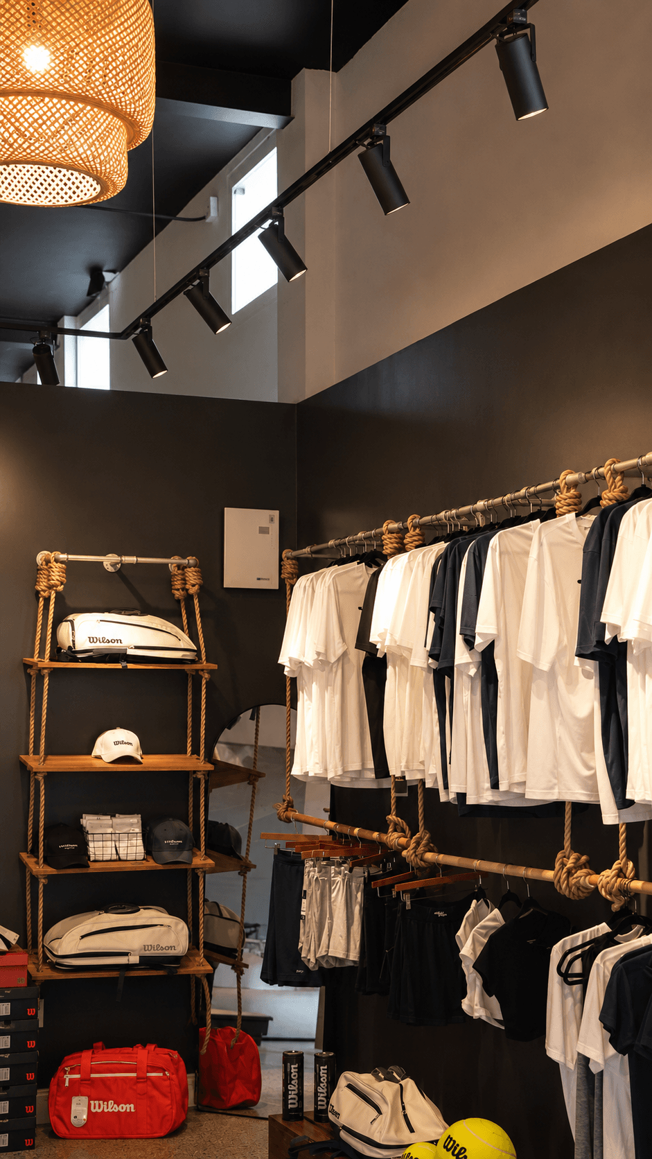 Vertical view of the pro shop wall of rackets and apparel